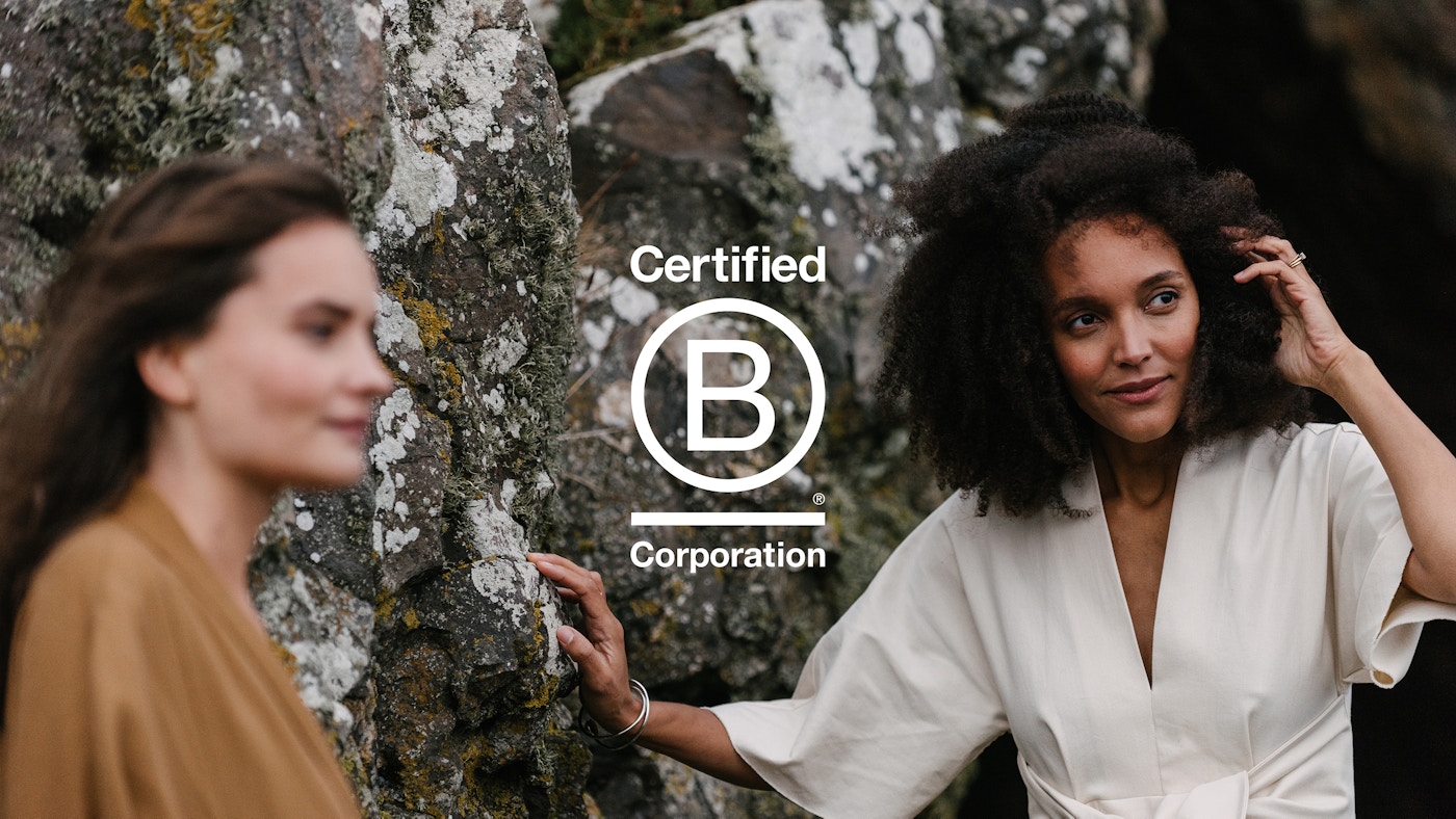 Two women standing in front of rocks. The B Corp logo has been placed on top.