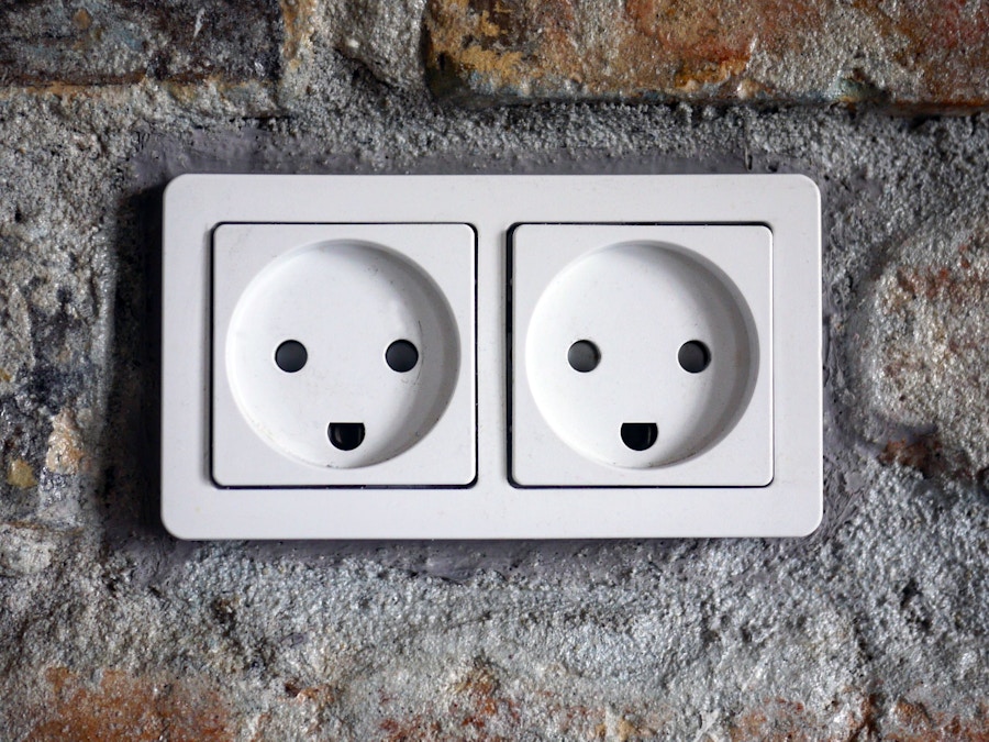 Two white plugs with holes that form a smiling face