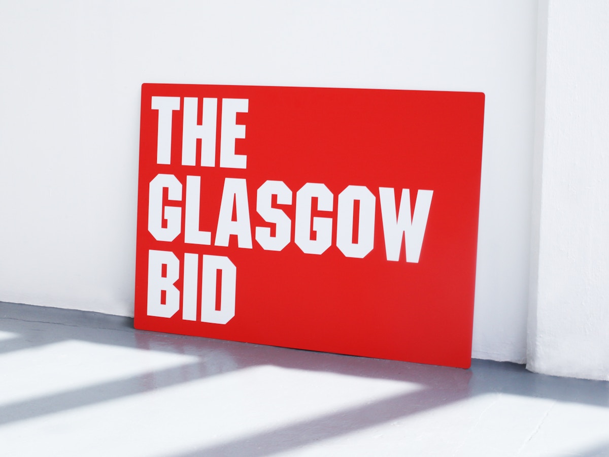 A large red exhibition panel that reads "The Glasgow bid" in angular, uppercase white lettering.