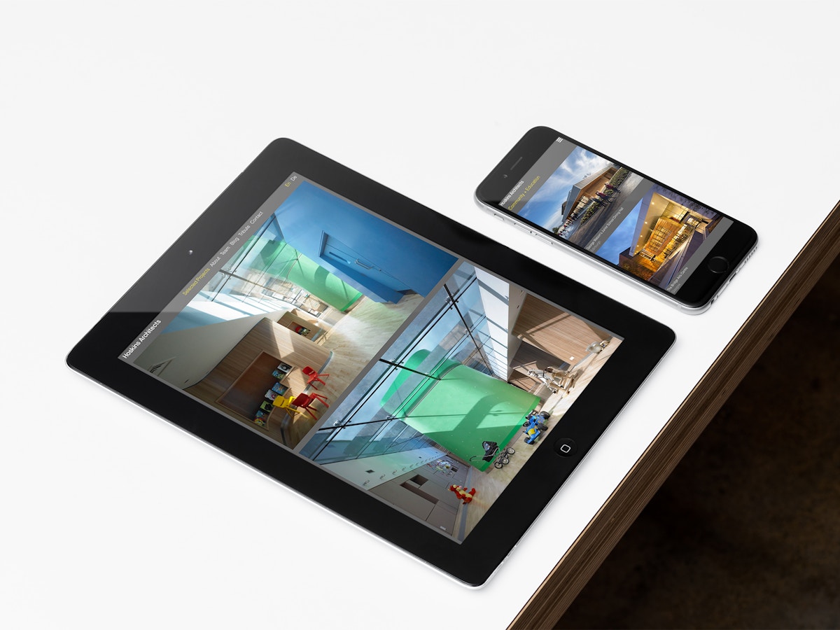 Mock up of website for Hoskins Architects on an iPad and iPhone on a white tabletop.