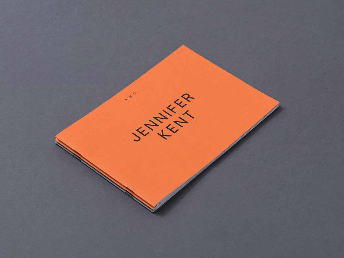 An orange booklet that has text on the front that reads "Jennifer Kent".