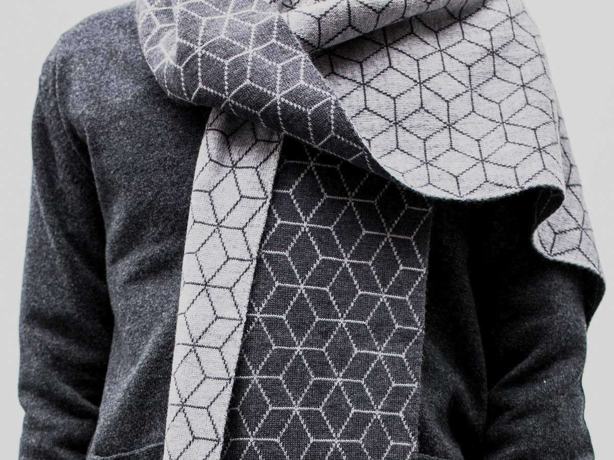 Detail of a man wearing a grey patterned scarf.
