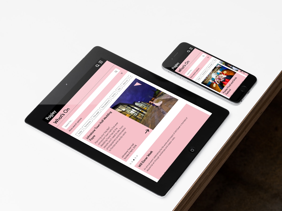 A mockup of a website shown on an iPad and an iPhone that are sitting on a white tabletop.